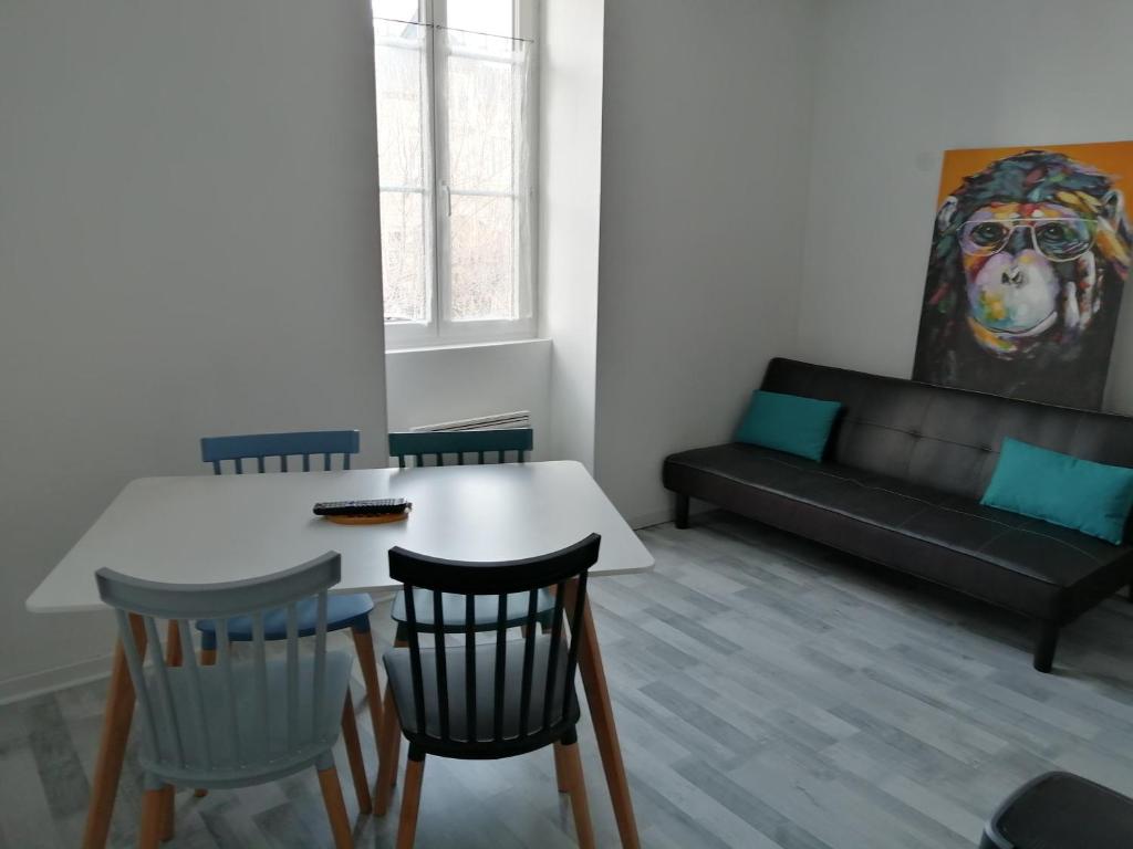 a living room with a table and chairs and a couch at 2 appartements au choix centre ville de Souillac entre Sarlat et Rocamadour in Souillac