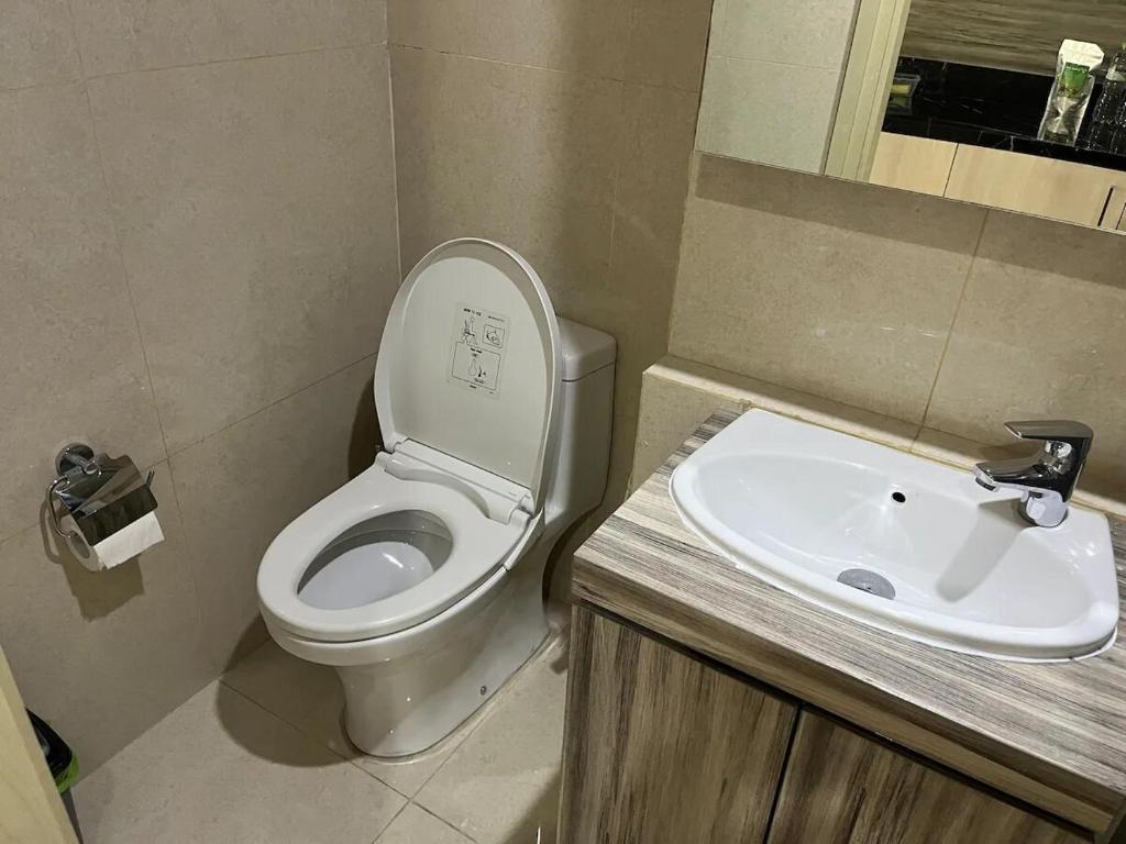 a bathroom with a toilet and a sink at Louis Kienne Simpang Lima in Semarang