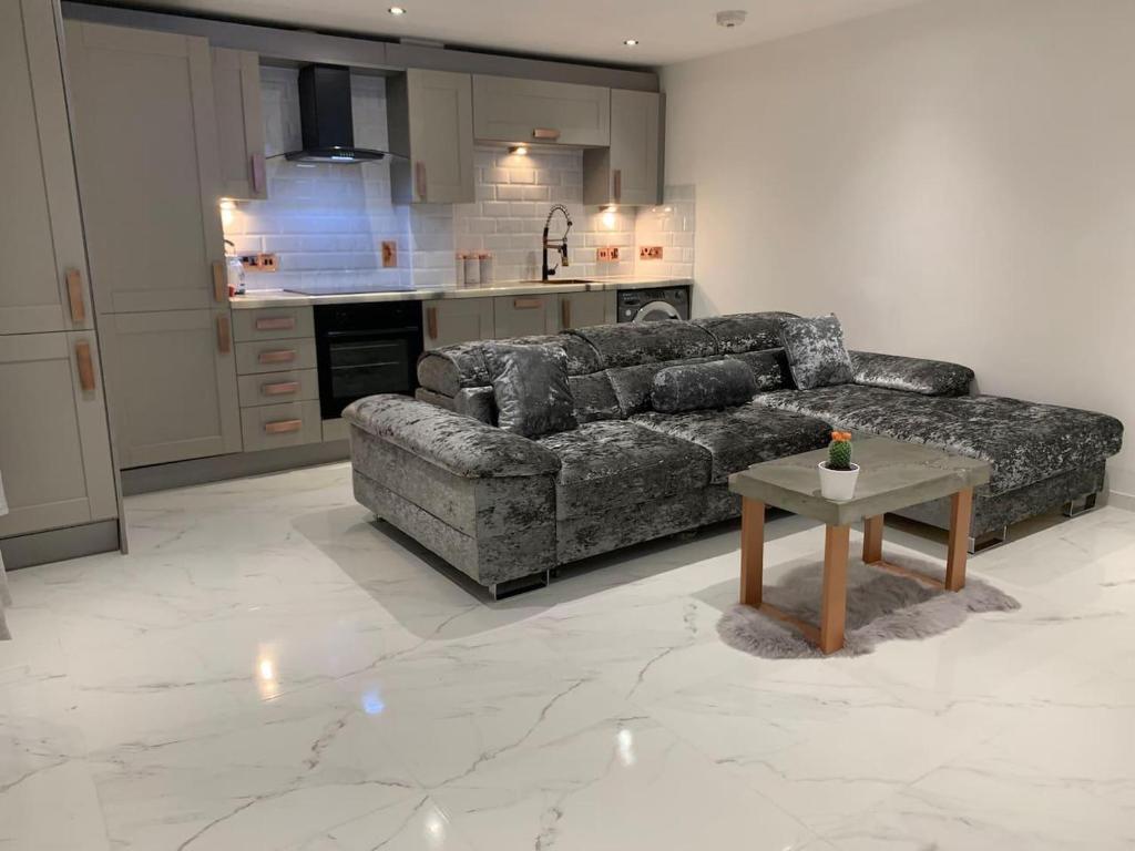 a living room with a couch and a table at Lavish The Marble Apartment in Bury Saint Edmunds