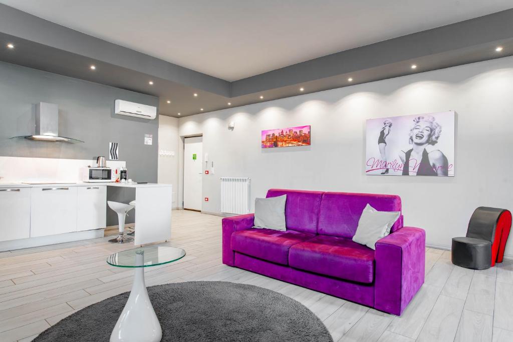 トリノにあるTorino Loftの紫色のソファ付きのリビングルーム、キッチンが備わります。