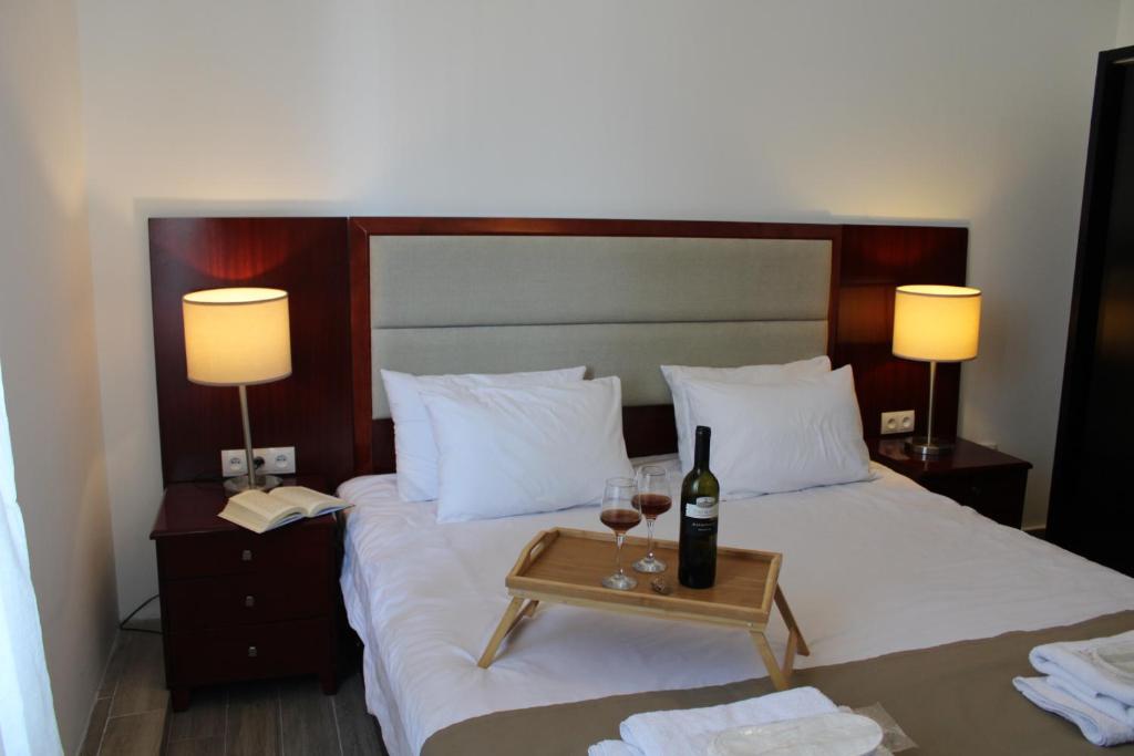 ein Bett mit einem Tisch, einer Flasche Wein und Gläsern in der Unterkunft Zhebota garden Tianeti in Zhebota