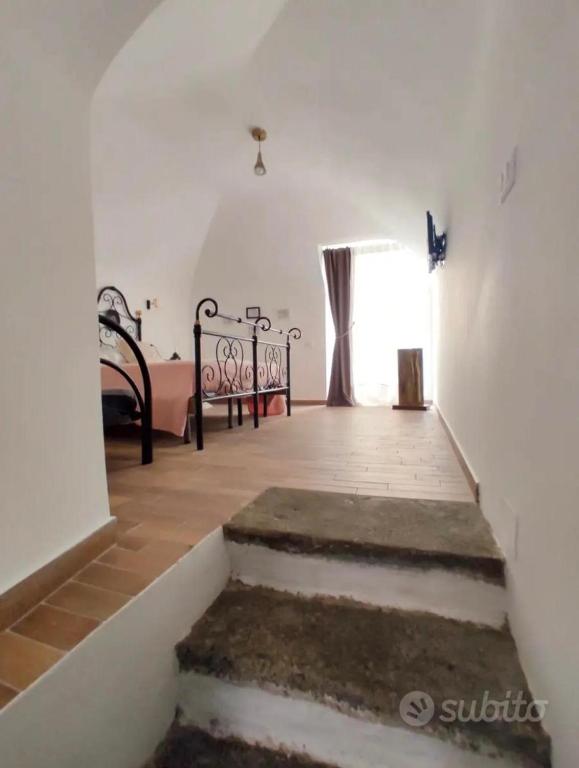 uma escada num quarto com uma cama e uma janela em Al Vicolo di Ercolano em Ercolano