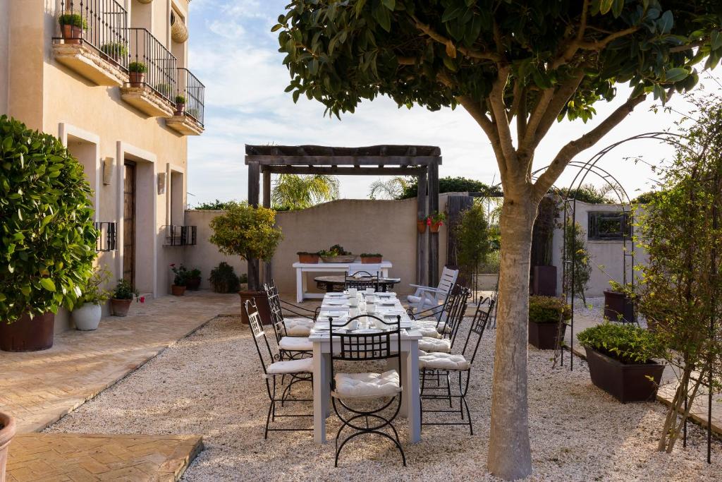 a table and chairs in a courtyard with a tree at Casa La Siesta in Vejer de la Frontera