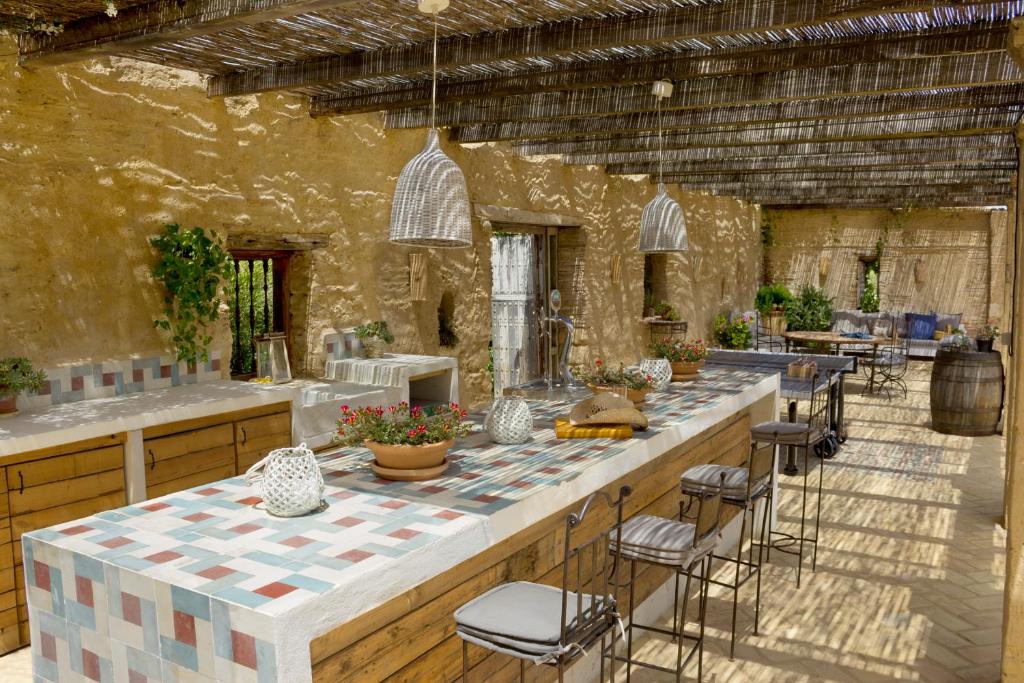 a large kitchen with a large counter with stools at Casa La Siesta in Vejer de la Frontera