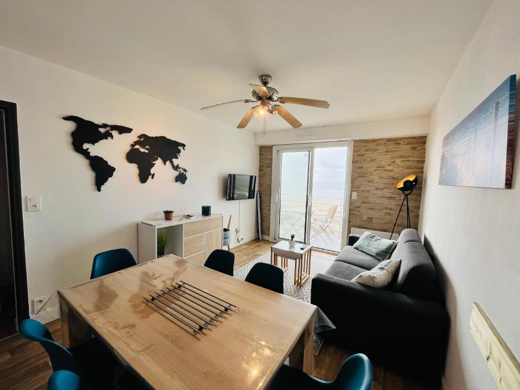 een woonkamer met een bank en een tafel bij Le Miramar, face mer et standing in Saint-Jean-de-Monts