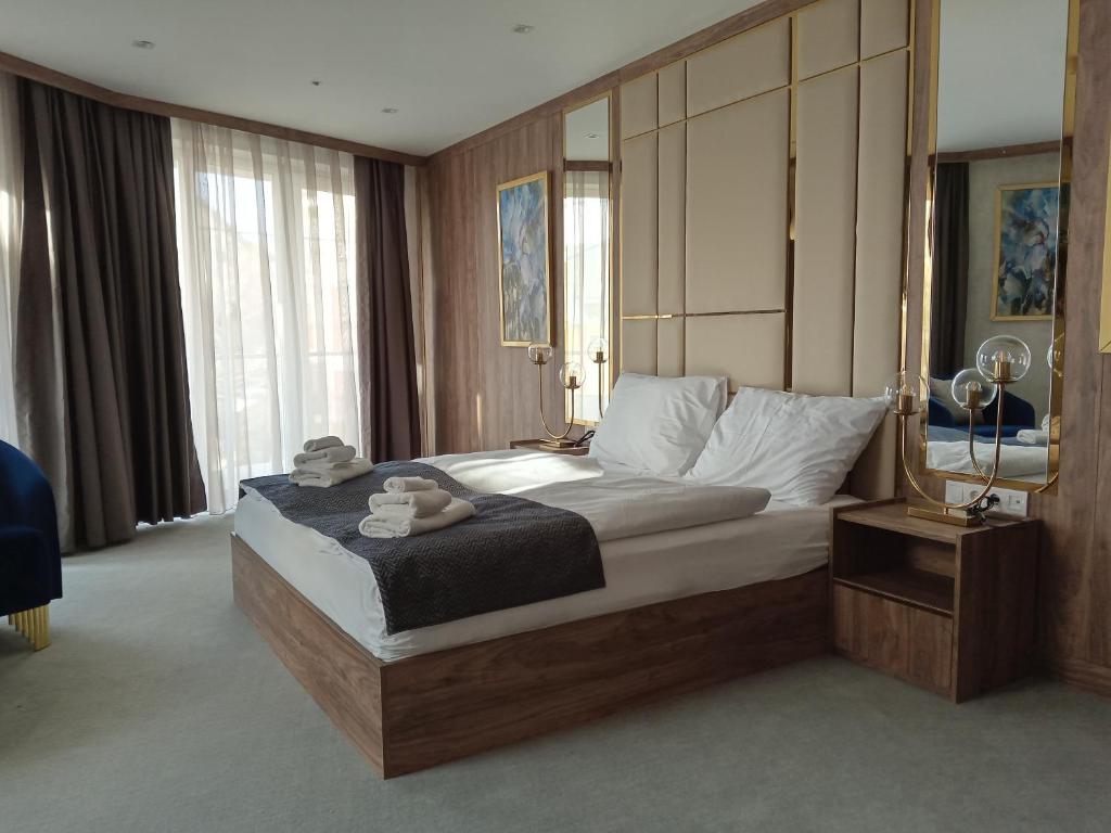 a bedroom with a large bed with a wooden headboard at Hotel Foldana in Budapest