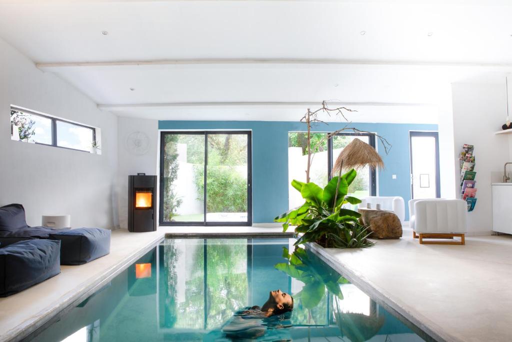 una piscina en una sala de estar con paredes azules en DODO etc - La Bastide du Vieux Chêne - TERITORIA, en Condorcet