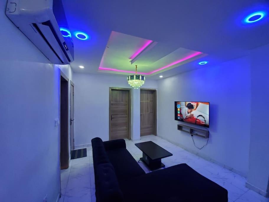 un soggiorno con divano e TV di Dinero Rose-2 Bedroom Apartment a Lagos