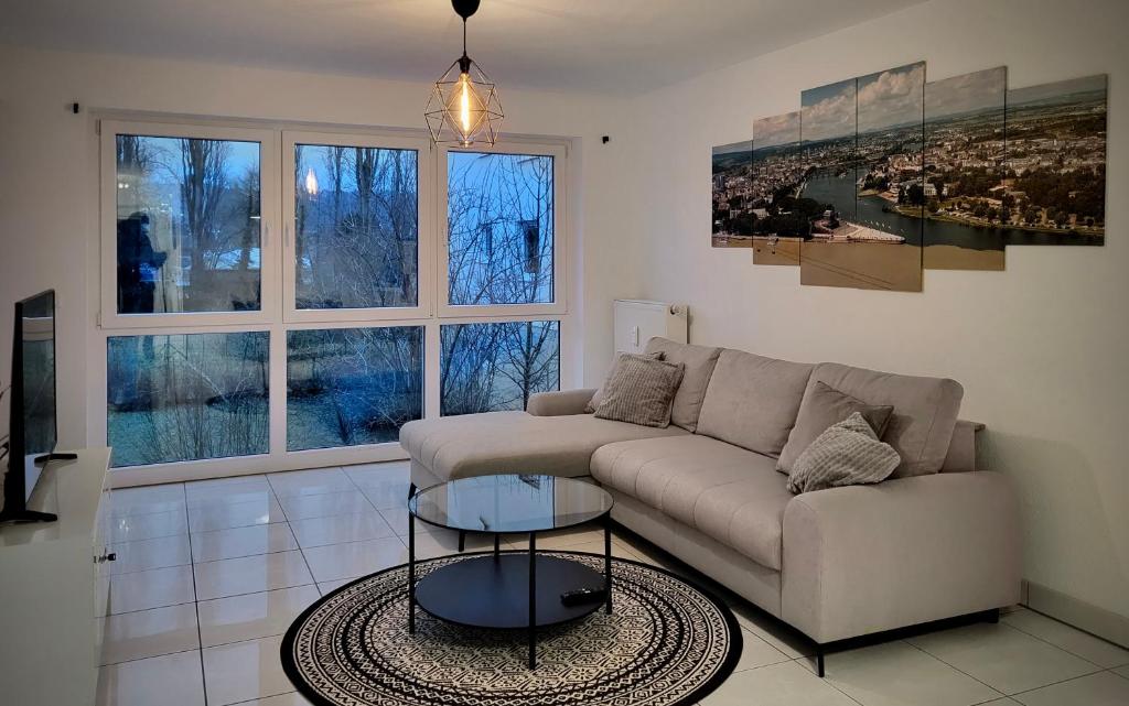 Schöne und ruhige Wohnung direkt an der Mosel في كوبلنز: غرفة معيشة مع أريكة وطاولة