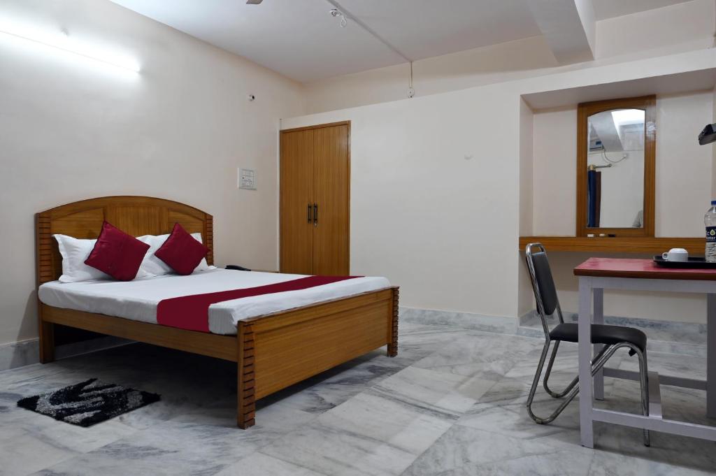 1 dormitorio con cama, mesa y escritorio en The Clovers Inn Boring Road, en Patna