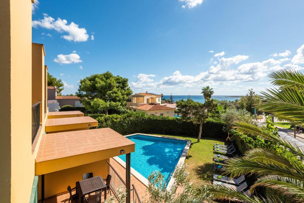 a view from the balcony of a house with a swimming pool at Apartamentos Punta Prima By EscapeHome in Punta Prima