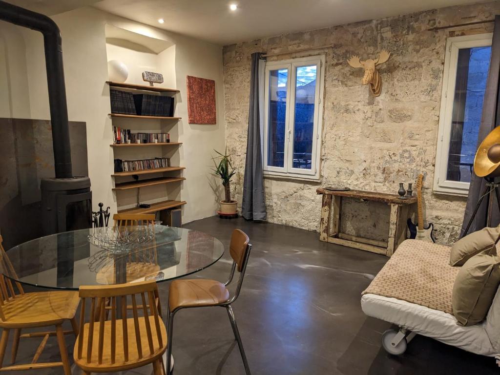 ein Wohnzimmer mit einem Glastisch und einem Kamin in der Unterkunft Appartement vintage in Avignon