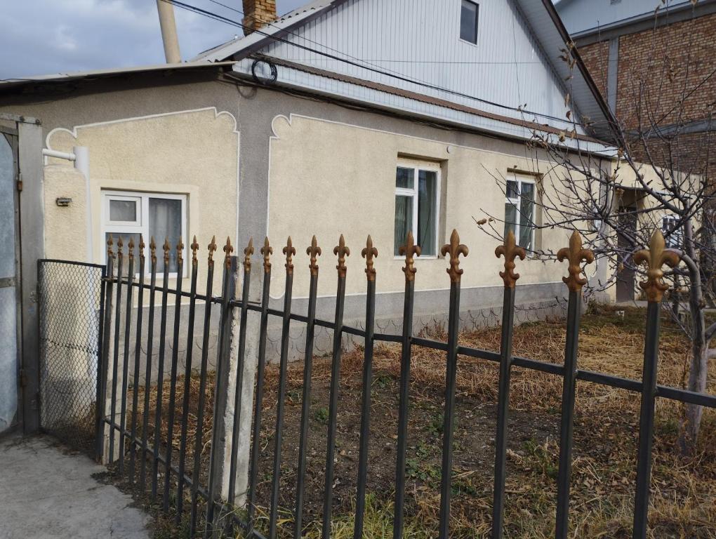 a black fence in front of a house at Guest house SONO adress Derbisheva 202 in Karakol