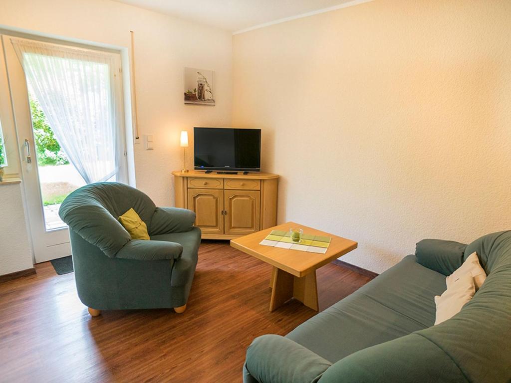 a living room with a couch and a table and a tv at Ferienwohnung Lennehof in Lennestadt