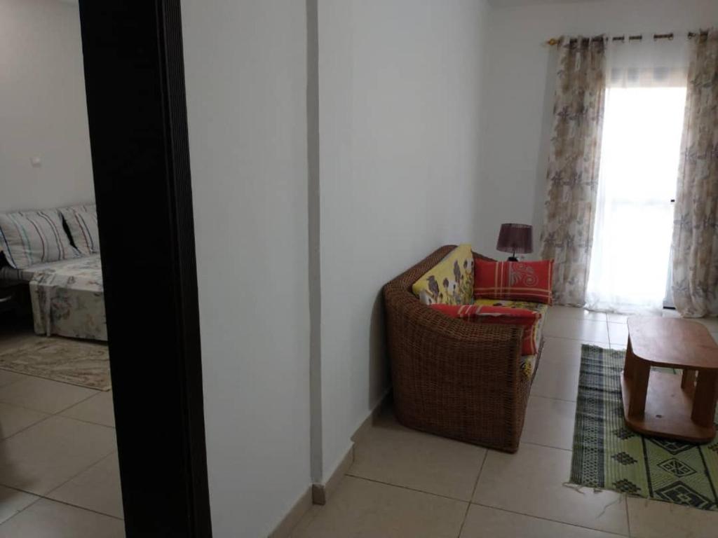 ein Wohnzimmer mit einem Stuhl und einem Fenster in der Unterkunft LES YILLAGA in Kribi
