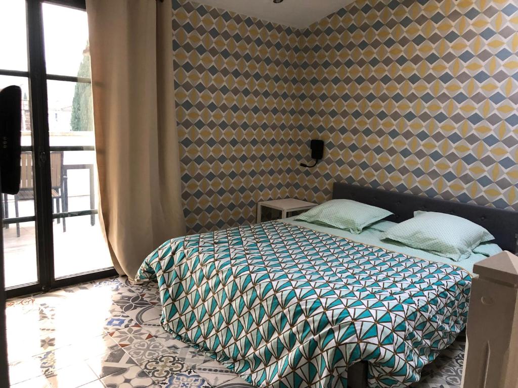 a bedroom with a bed with a patterned wall at Carcahouse in Carcassonne