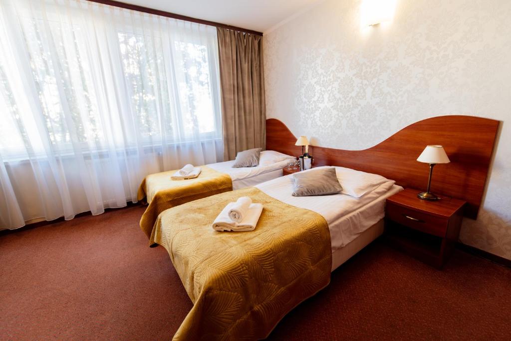 a hotel room with two beds and a window at Hotel Grand Felix in Kraków