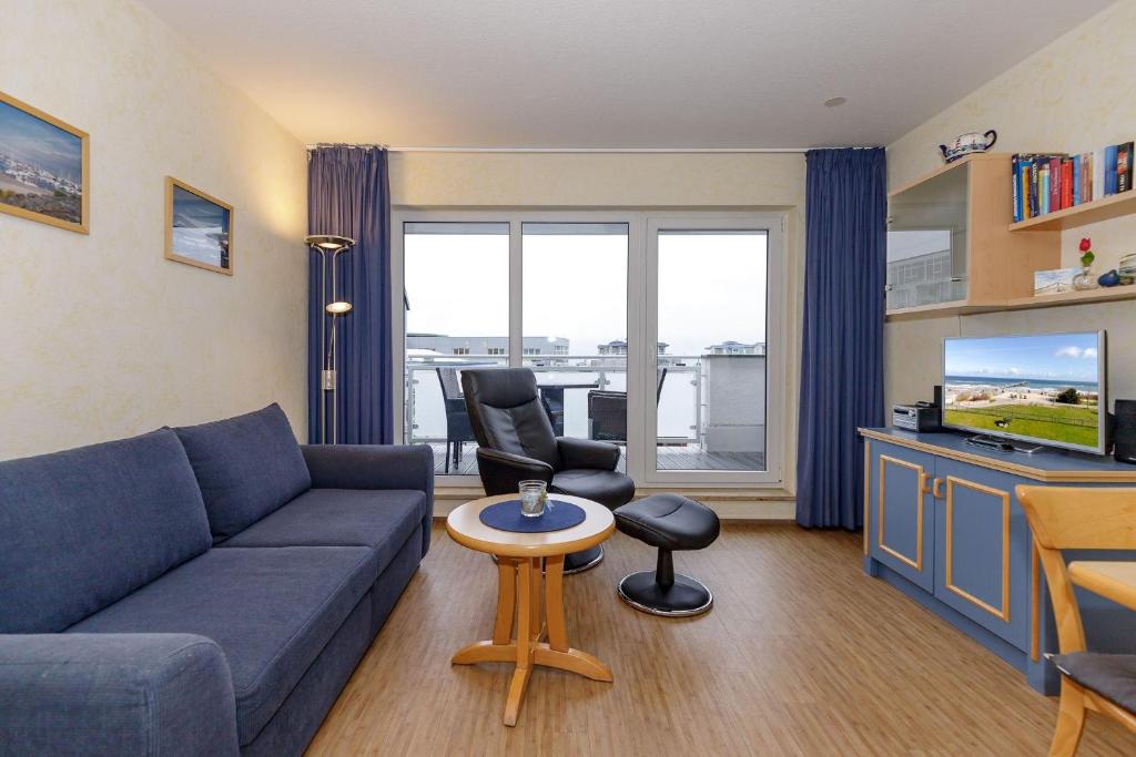 キュールングスボルンにあるYachthafenresidenz-Wohnung-9309-906のリビングルーム(青いソファ、テレビ付)