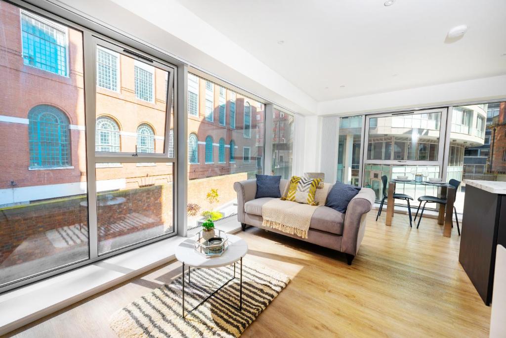 a living room with a couch and large windows at Luxury City Centre Apartment - Family Friendly in Liverpool