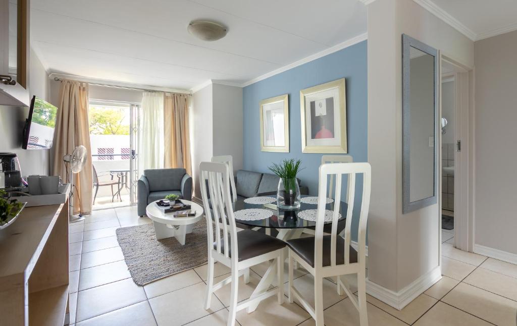 Johannesburg的住宿－Radstays - 43 Madison Palms，厨房以及带桌椅的起居室。