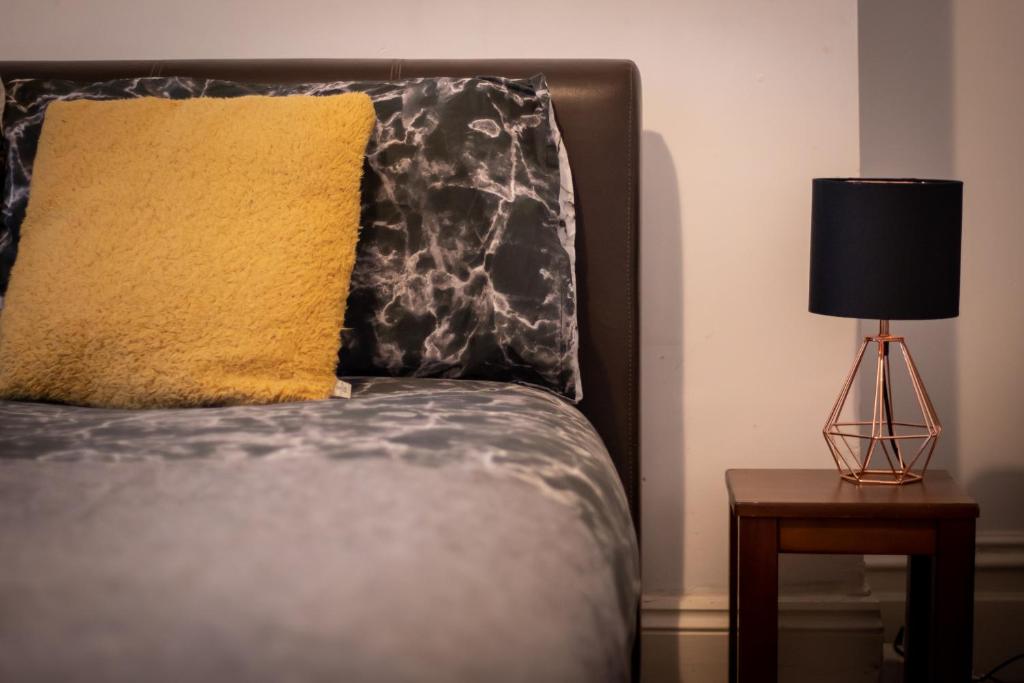 ein Bett mit einem gelben Kissen und einer Lampe auf dem Tisch in der Unterkunft Lovely Apartment in Old Walker