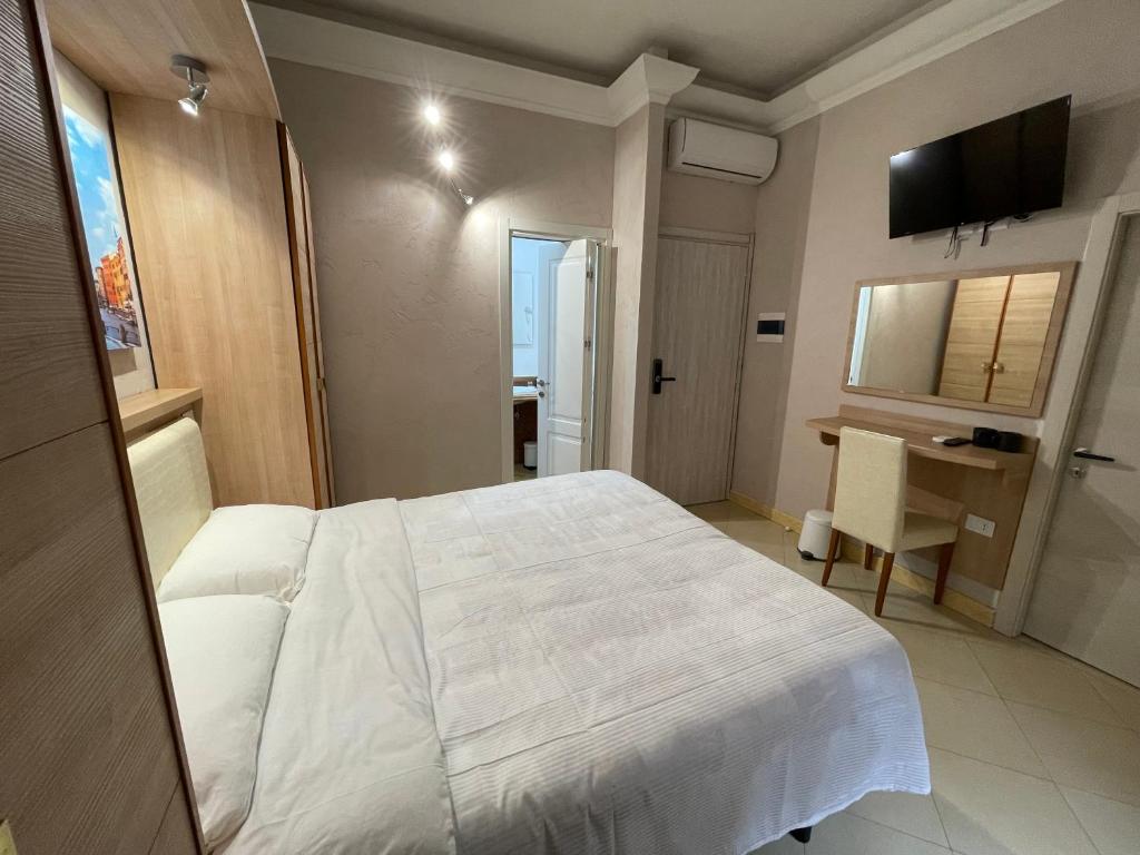 a bedroom with a white bed and a desk at Ambasada Suite in Rome