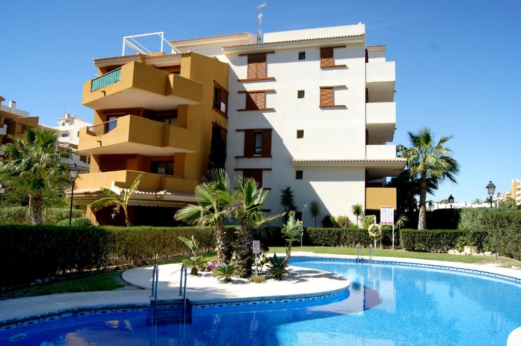 een gebouw en een zwembad voor een gebouw bij Parque Recoleta 2 PISCINAS - CERCA DE PLAYA in Punta Prima