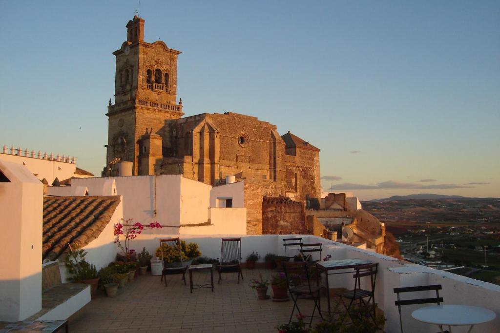 a church on top of a hill with tables and chairs at La Casa Grande in Arcos de la Frontera