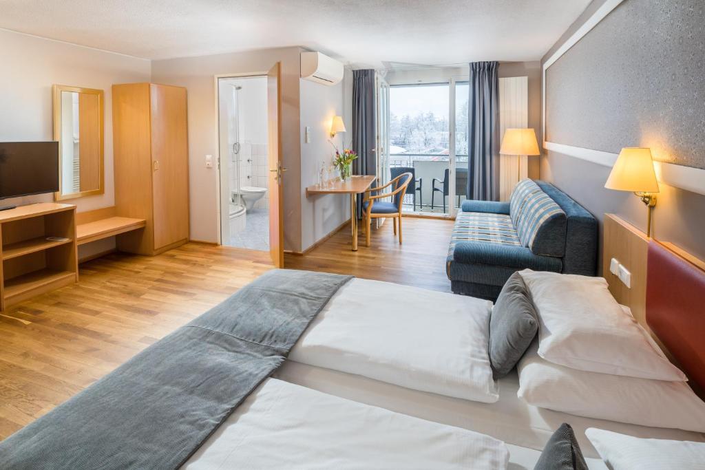 Habitación de hotel con cama y sala de estar. en Hotel Classic en Friburgo de Brisgovia