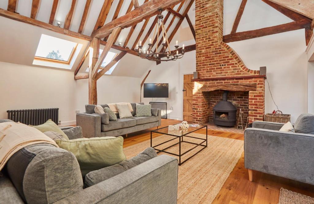 a living room with two couches and a fireplace at The Coach House, Hambledon in Hambledon