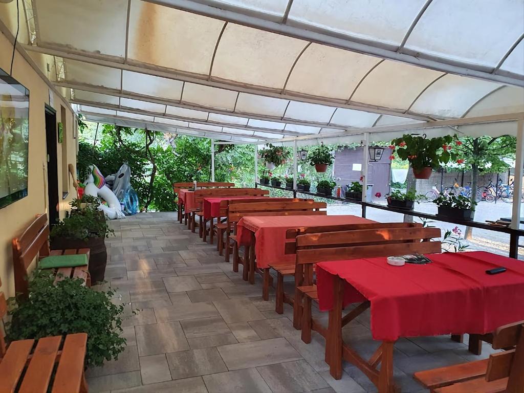 a row of tables with red table cloths in a restaurant at Eldoradó Fogadó és Kemping in Vonyarcvashegy