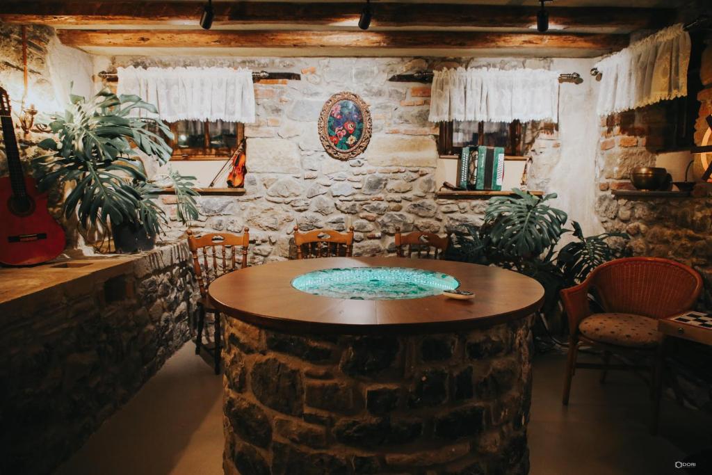 a room with a stone wall with a table and chairs at Vila Sonnet in Korçë