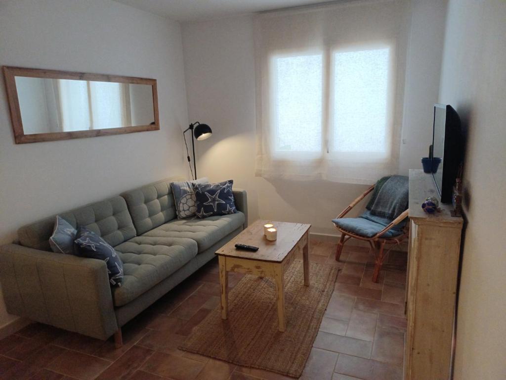 ein Wohnzimmer mit einem Sofa und einem Tisch in der Unterkunft Apto 1a línea del Paseo Llafranc con Aire acondicionado Sin Vistas in Llafranc