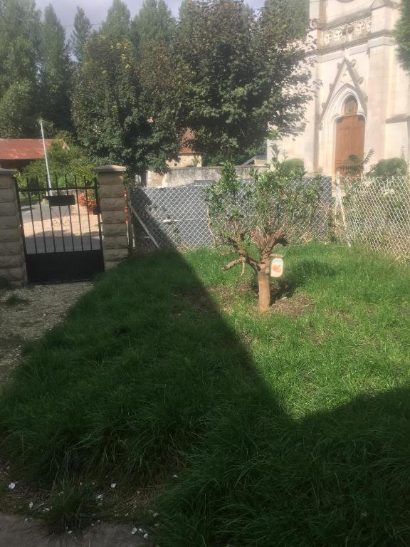 une ombre d'une clôture et d'un arbre dans une cour dans l'établissement VERONIQUE 58 ANNAY, à Annay