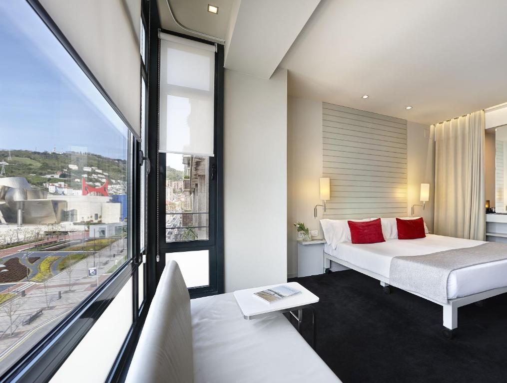 1 dormitorio con cama y ventana grande en Hotel Miró, en Bilbao