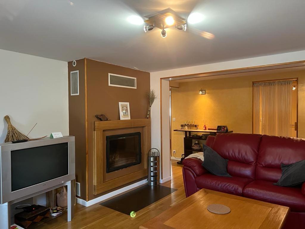 a living room with a red couch and a tv at Aulnay cocoon in Aulnay-sous-Bois