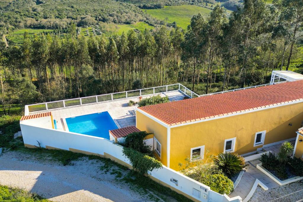 einen Luftblick auf ein gelbes Haus mit einem Pool in der Unterkunft Casa Amarela - Countryside Villa by LovelyStay in Alcobaça
