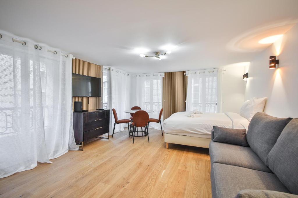 Hotel 33.Studio 4Pers#Madeleine#Gallerie La Fayette, a hotel room with a bed and a couch at 33.Studio 4Pers#Madeleine#Gallerie La Fayette in Paris