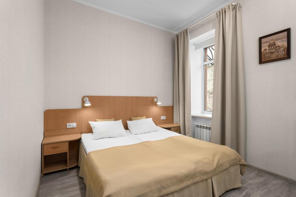 Schlafzimmer mit einem Bett, einem Schreibtisch und einem Fenster in der Unterkunft Vesta in Sankt Petersburg