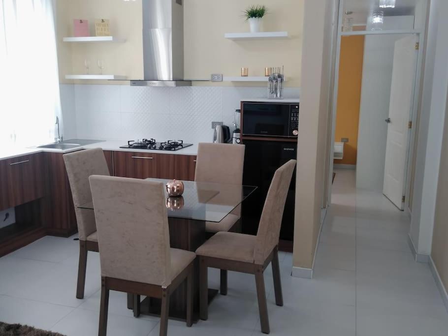 een keuken met een tafel en stoelen en een fornuis bij (3P)Gerard Diva House in Huancayo