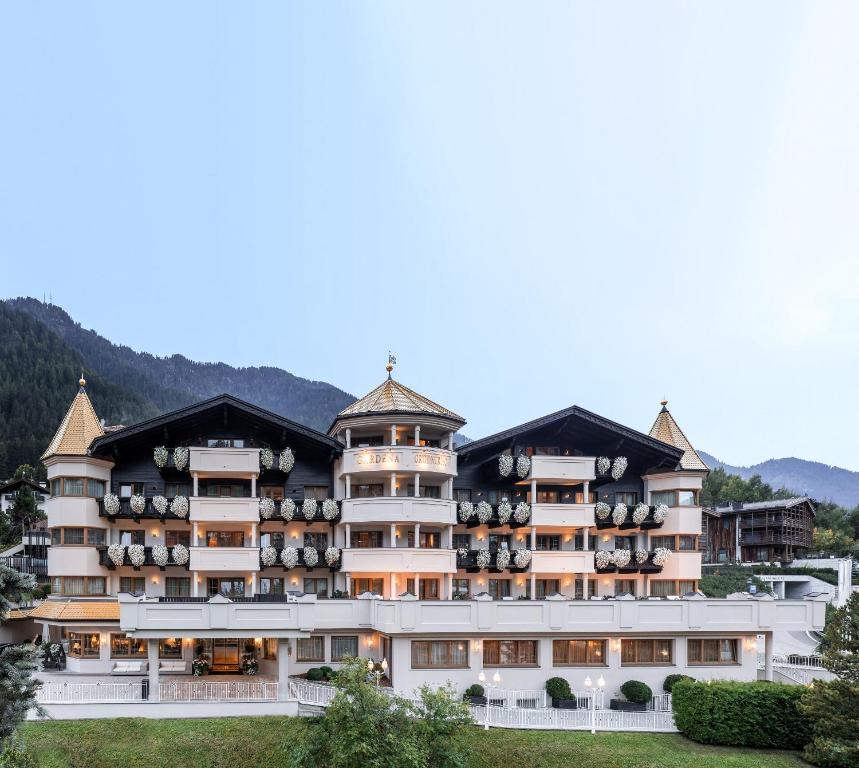 a large building with balconies on top of it at Gardena Grödnerhof - Hotel & Spa in Ortisei