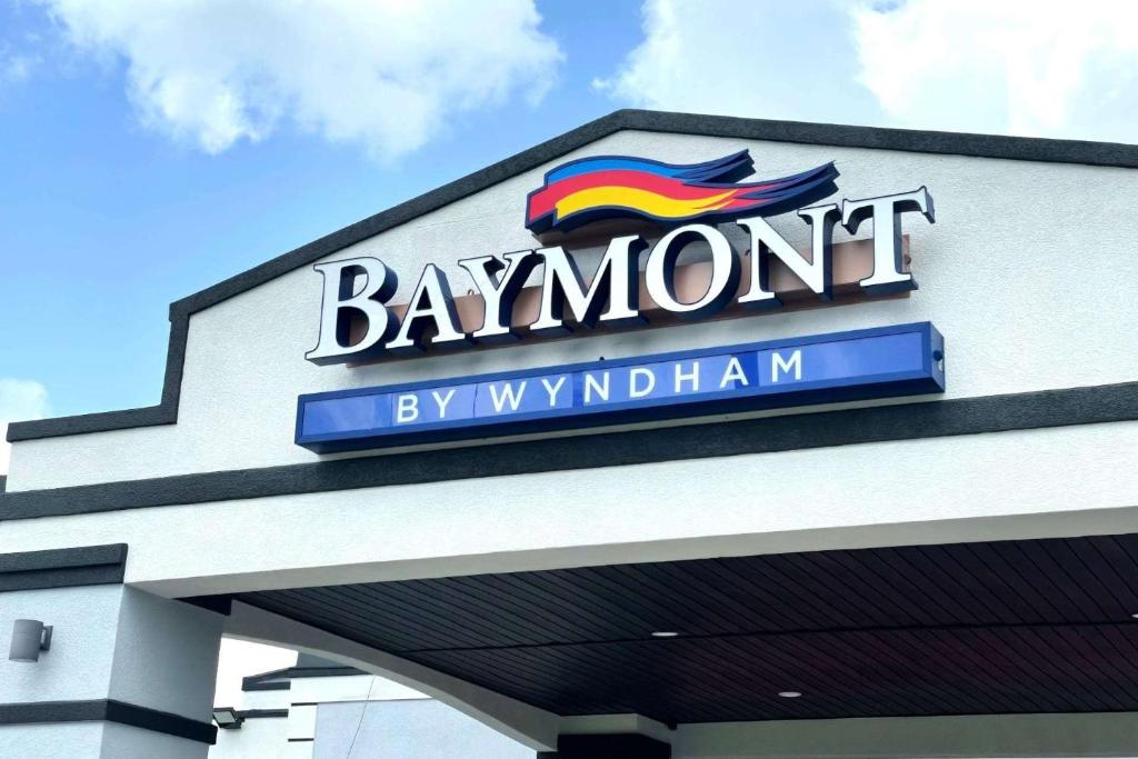 een bord aan de zijkant van een gebouw met een regenboog bij Baymont by Wyndham Dothan in Dothan