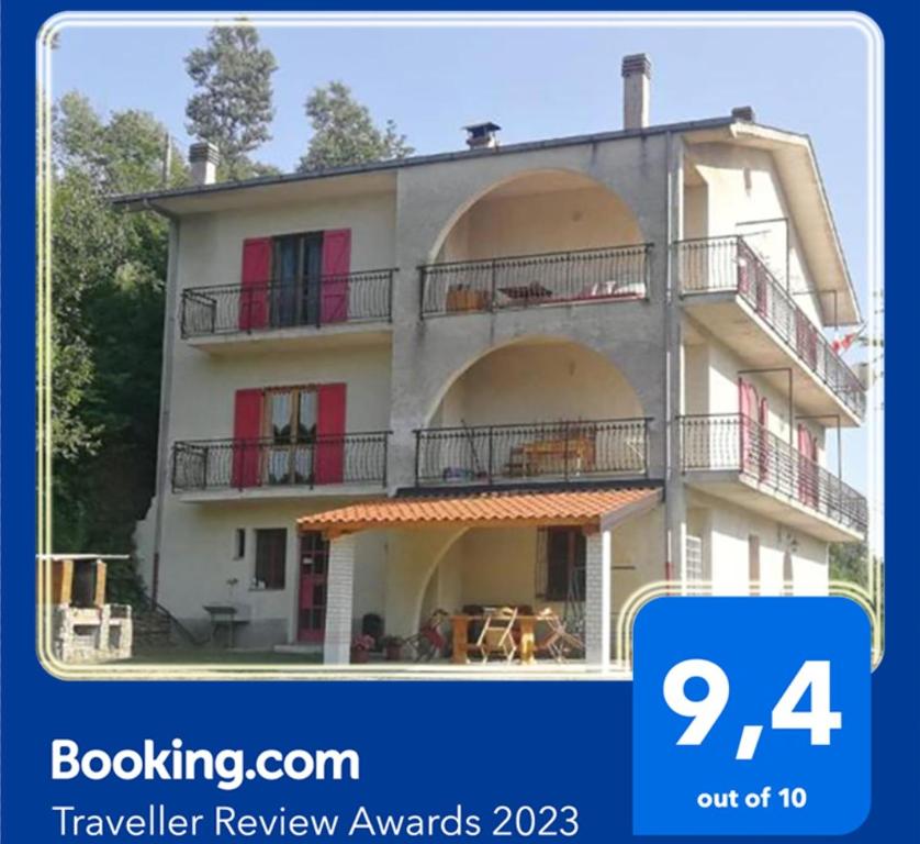 ein großes weißes Gebäude mit roten Türen und Balkonen in der Unterkunft Casa panoramica tra mare e montagna alle pendici della Sila in Bianchi