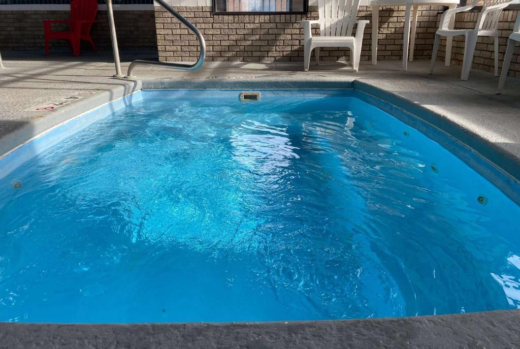 uma piscina azul com cadeiras em Wingate by Wyndham Gunnison Near Western Colorado University em Gunnison