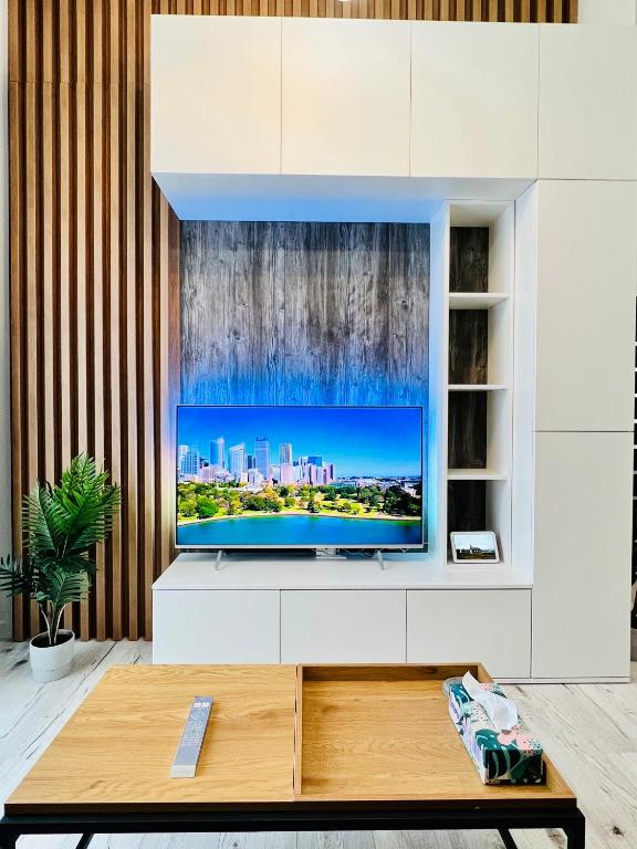 a living room with a television on a white cabinet at Altheda Living Topaz 29C-14 in Sfîntu Ilie