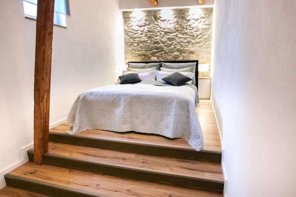 a bedroom with a bed with a white comforter at Ferienhaus am Schlossberg in Ranis in Ranis