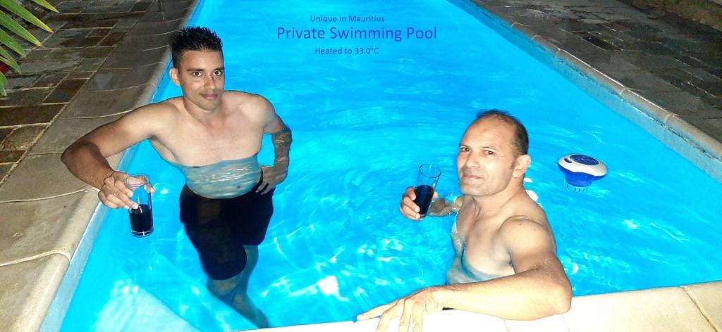 two men standing in a swimming pool at Sea 11 Villas with Personal Heated Pools in Grand-Baie