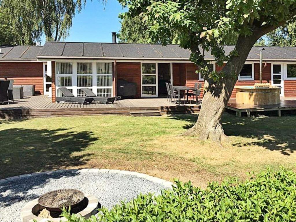une maison avec un arbre dans la cour dans l'établissement 10 person holiday home in Juelsminde, à Juelsminde
