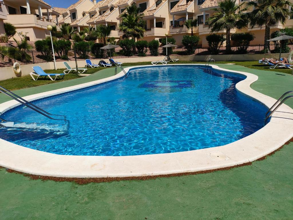 ein großer Pool mit blauem Wasser in einem Resort in der Unterkunft Casas Holiday - Golf Campoamor in Orihuela
