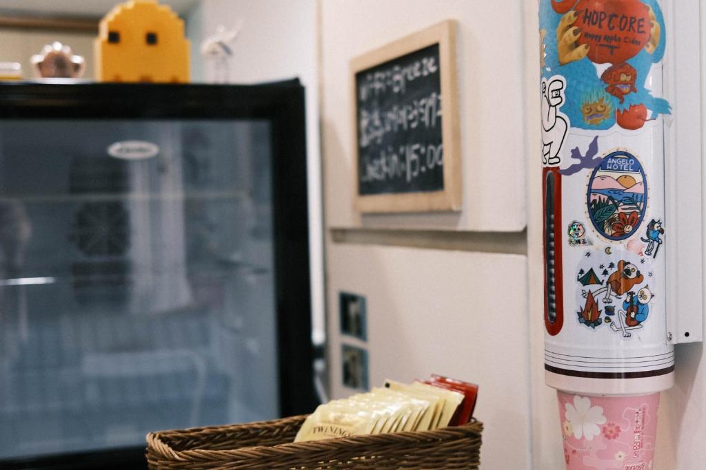 a refrigerator with stickers on it next to a basket at Jiufen Breeze 九份惠風民宿ｌ6人包棟小屋 in Jiufen